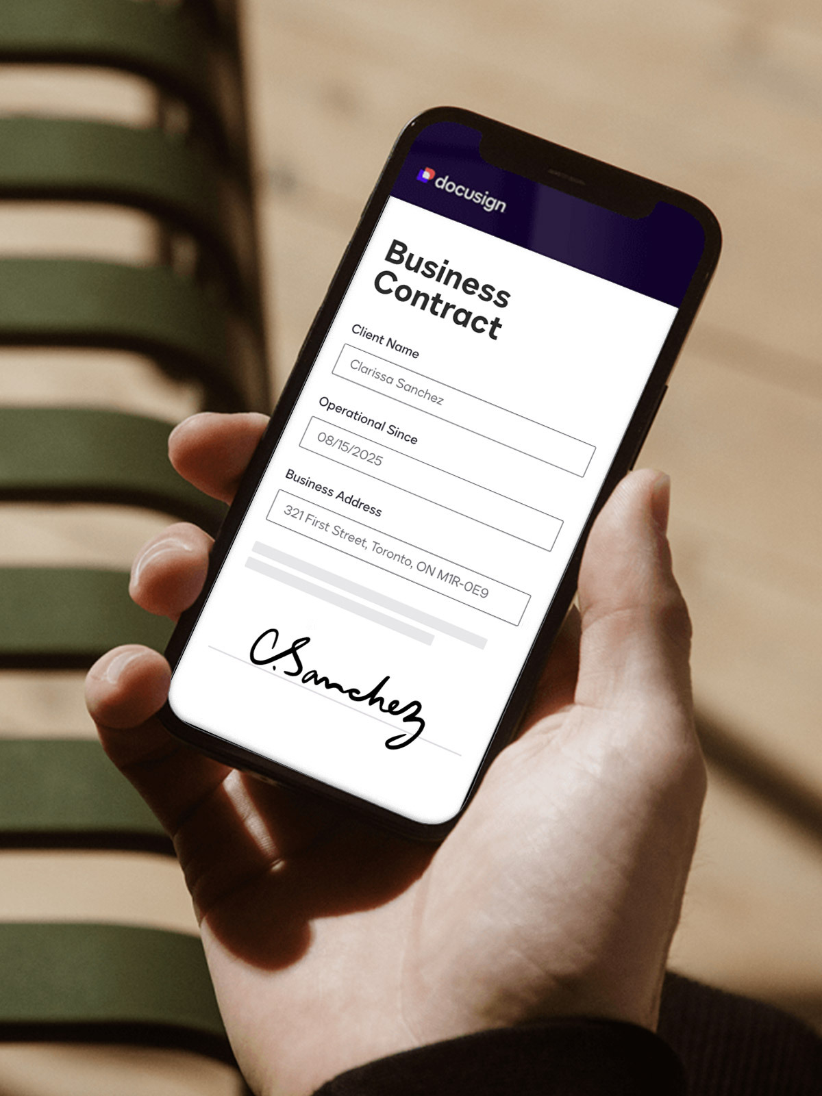 A person holding a cell phone with a contract on the screen