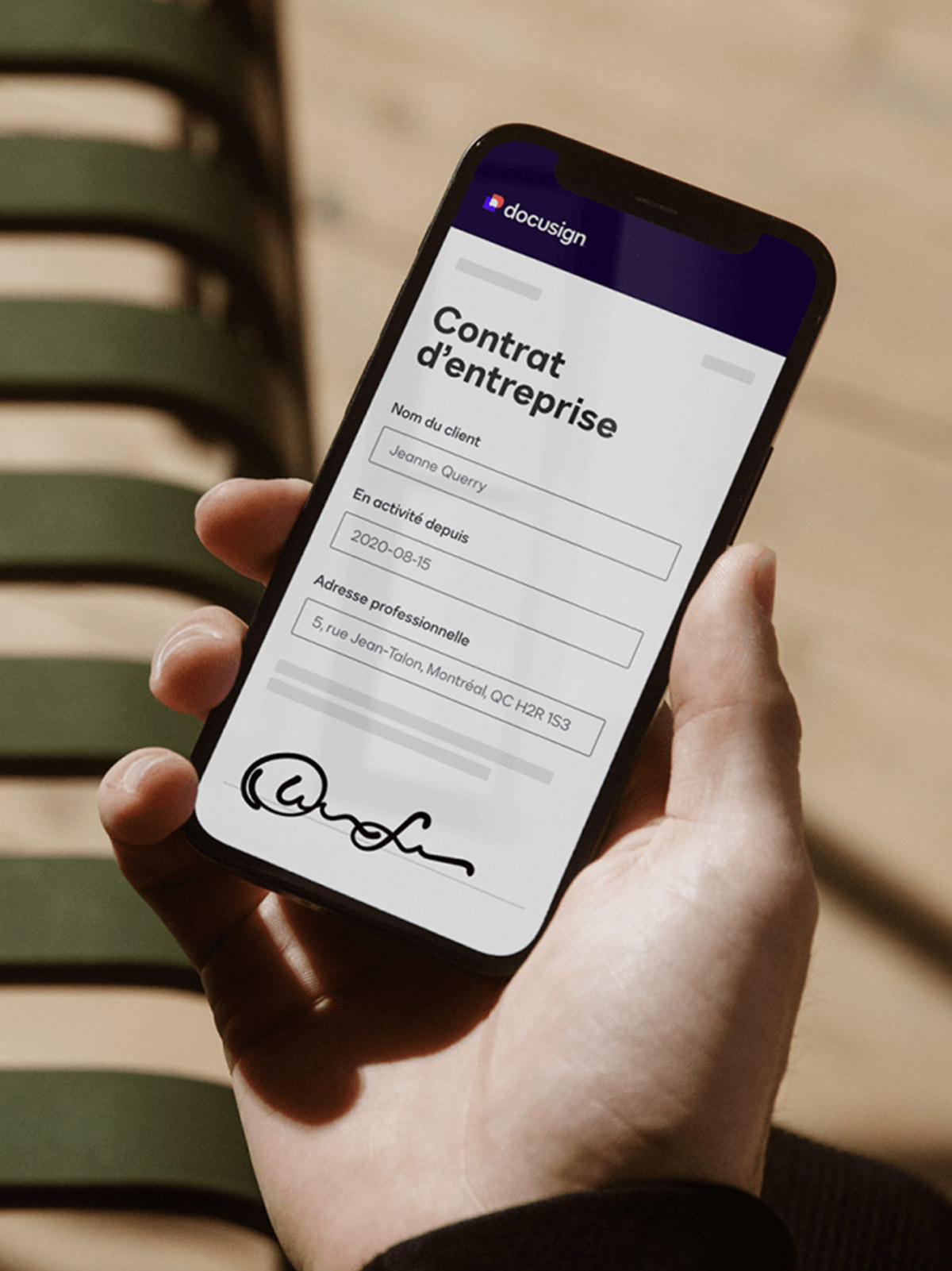 Une personne tenant un téléphone cellulaire avec un contrat à l'écran