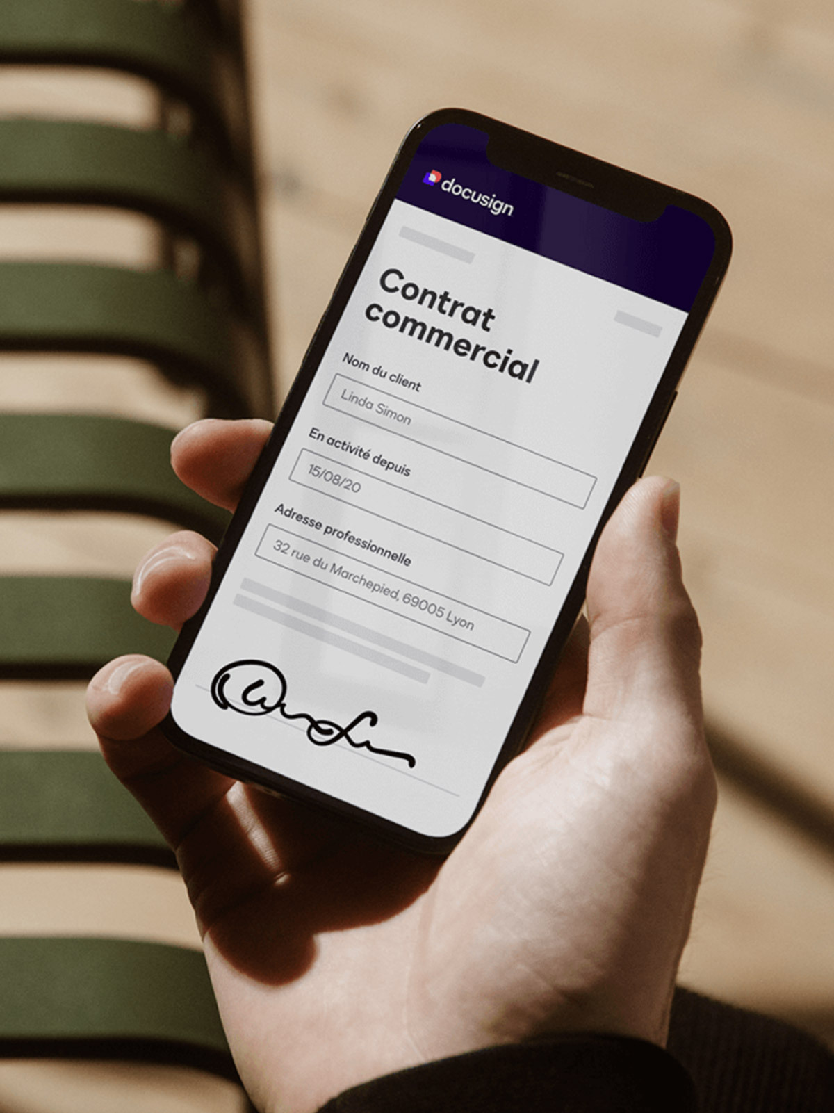 Une personne tenant un téléphone portable avec un contrat sur l'écran