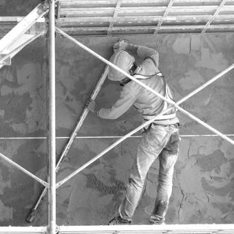Imagem em preto e branco de um profissional da construção