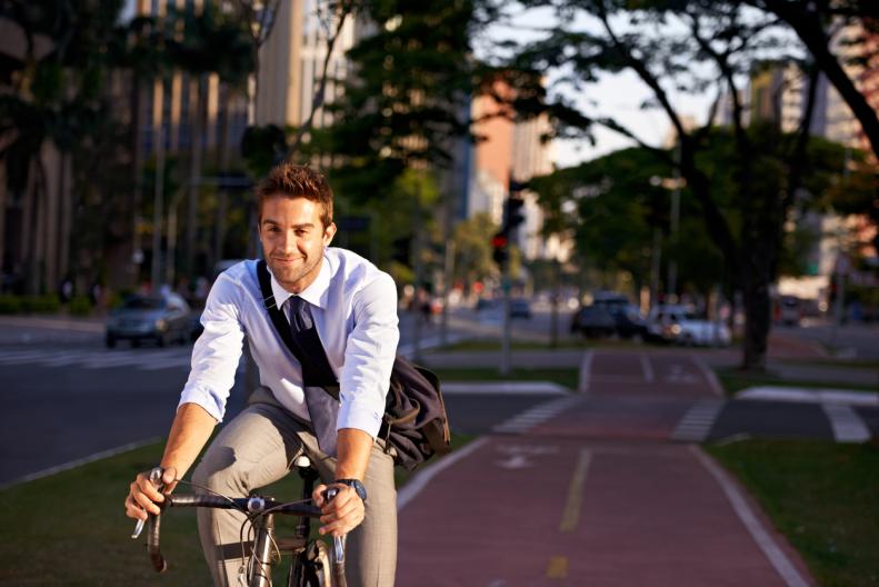 Um jovem executivo pedala na ciclovia