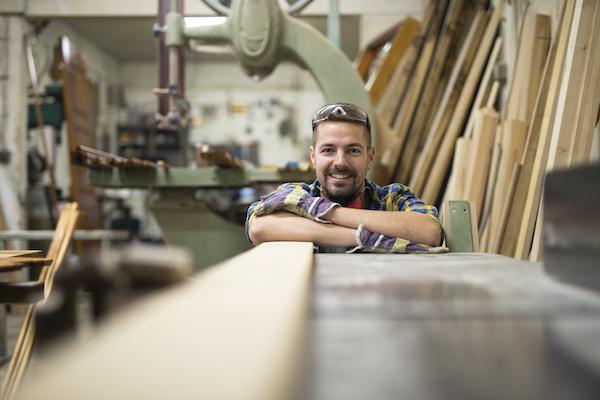 smiling man in woodshop - procurement