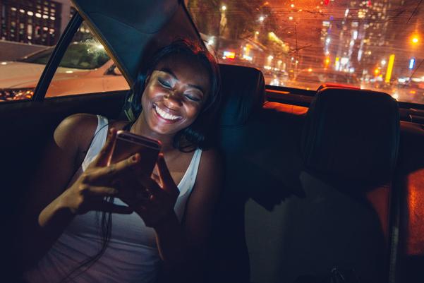 mujer firma un documento en su celular dentro de un taxi