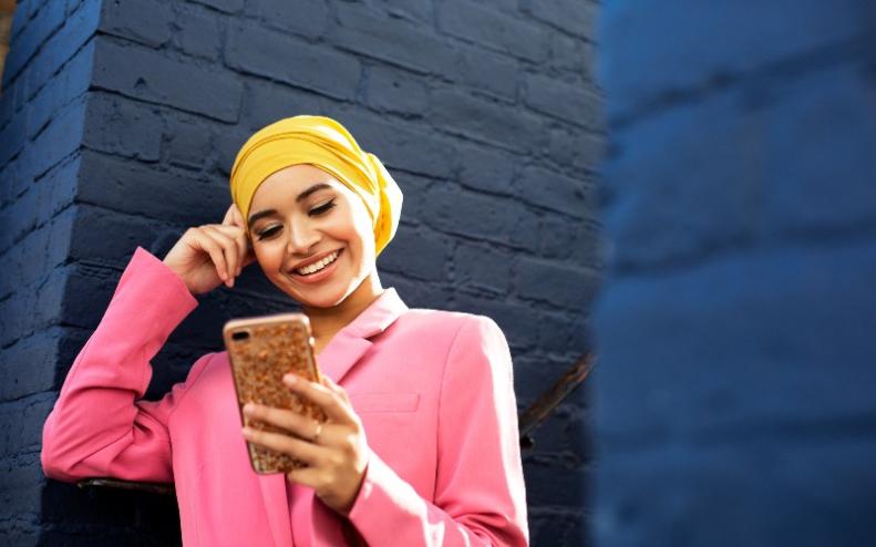 Una joven árabe lee mensajes en su celular