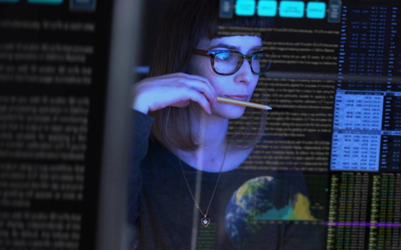 Una mujer mira códigos de seguridad en la pantalla de su computadora 