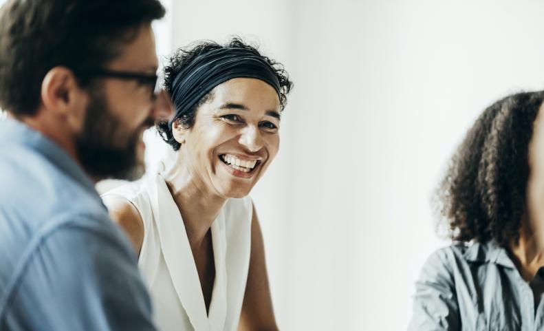 Woman Smiling While Talking With Office Colleagues