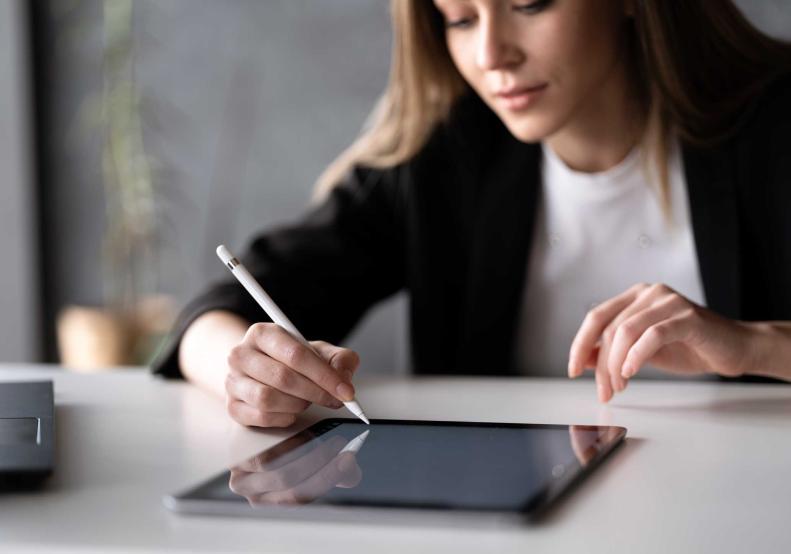 Una joven firma un contrato en una pantalla de tableta