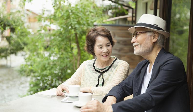 屋外カフェでお茶する高齢者夫婦