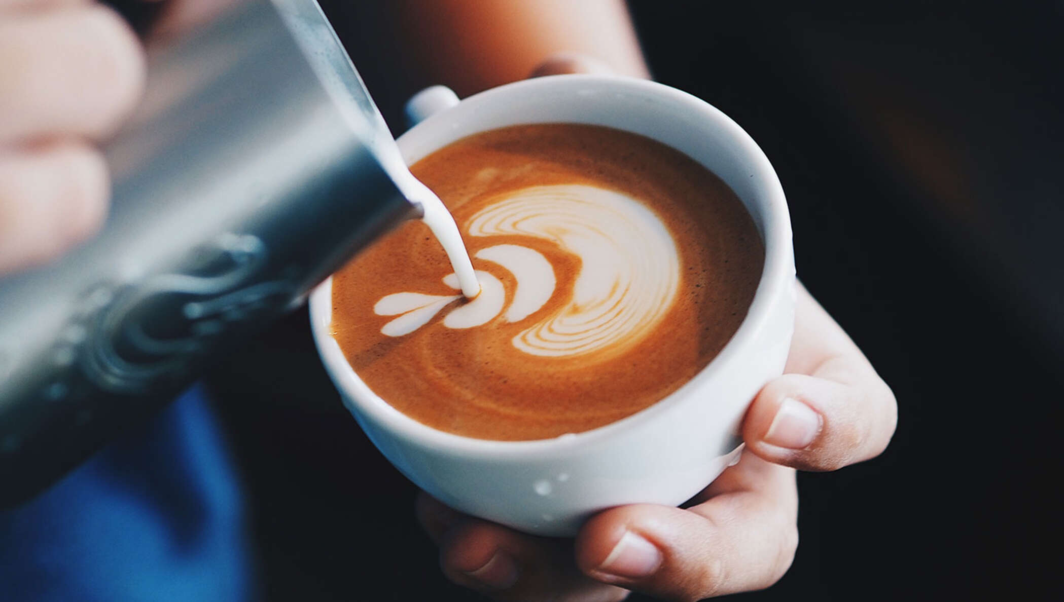 Close-up of hand holding a coffee cup.