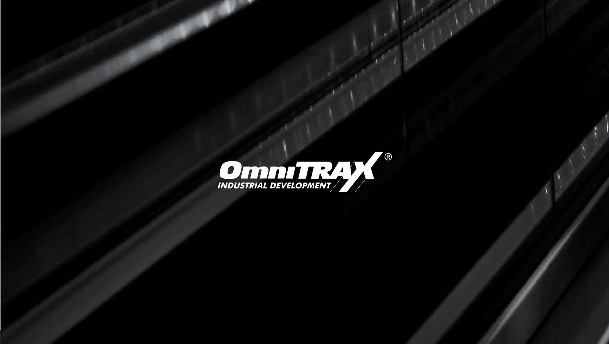 A white OmniTrax company logo sits in front of a dark gray abstraction of railroad tracks.