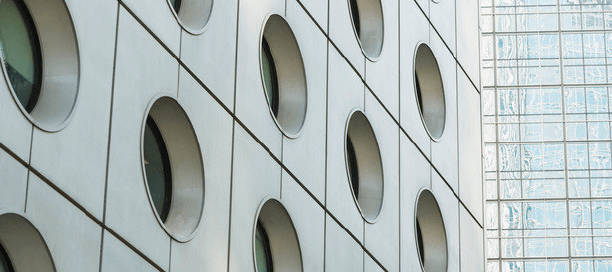 The side of a large building with circular windows.