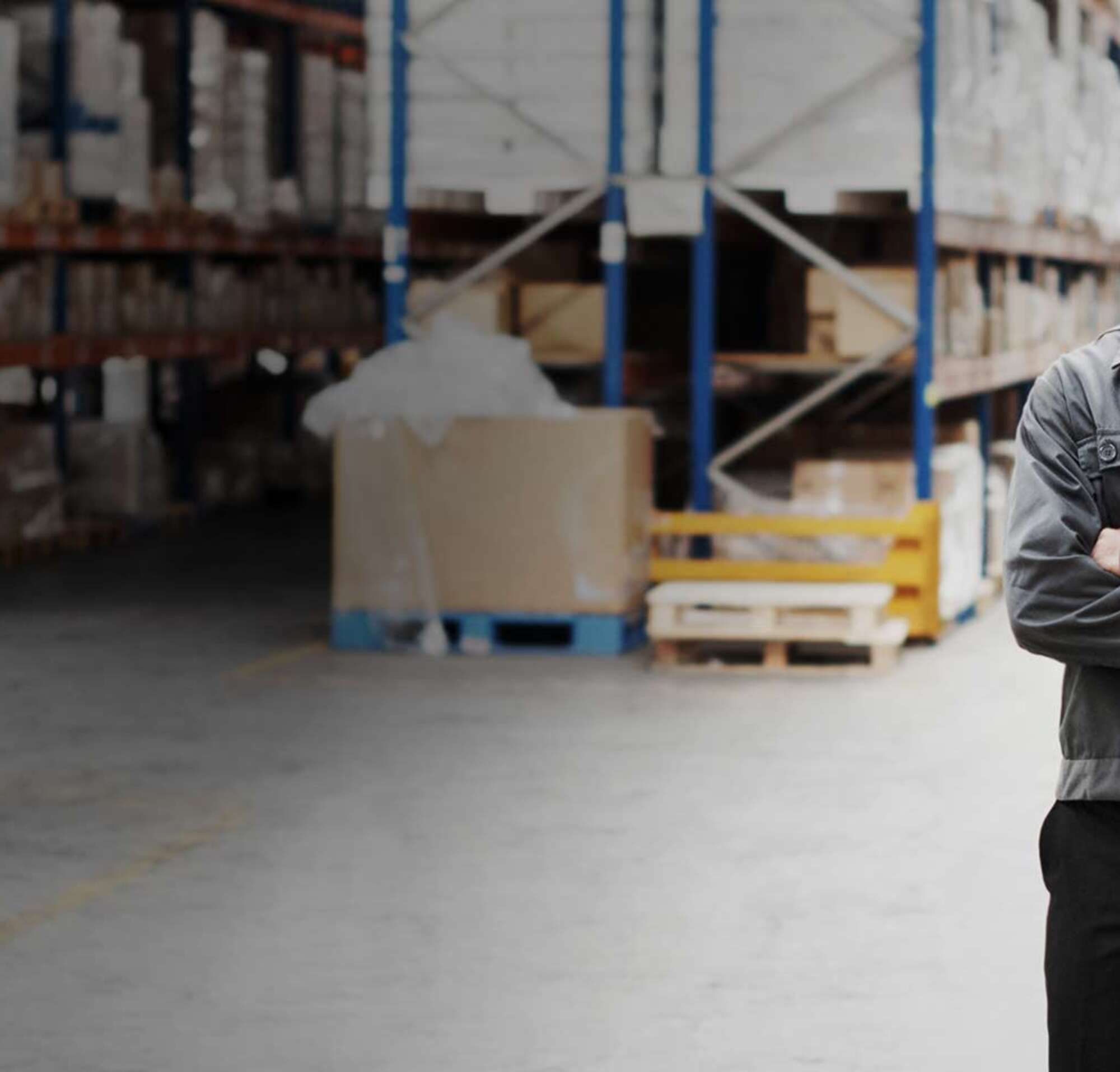 Homem de pé em um armazém totalmente abastecido.