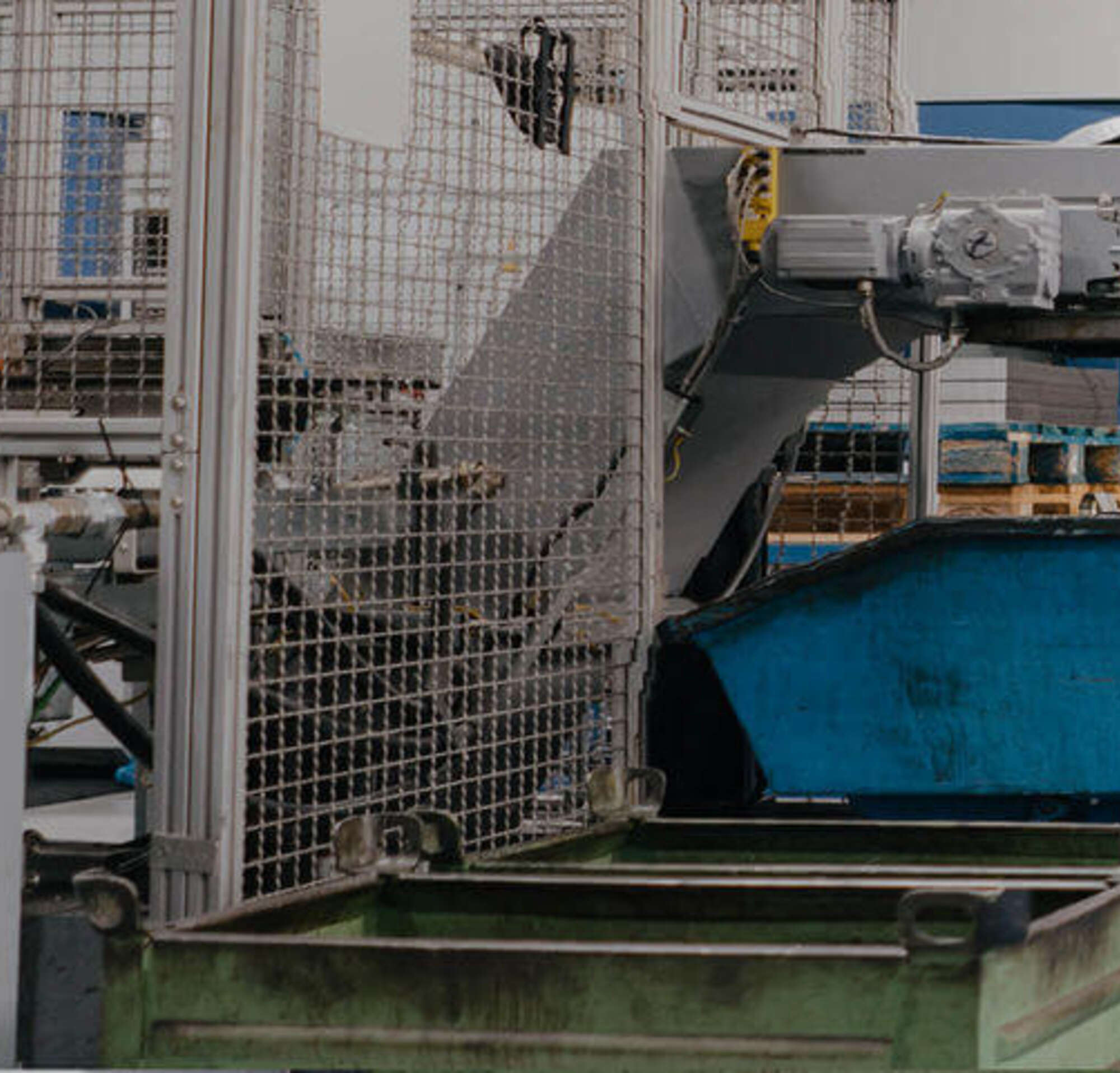 Un hombre en un traje caminando con una obrera dentro de una fábrica con maquinaria grande.