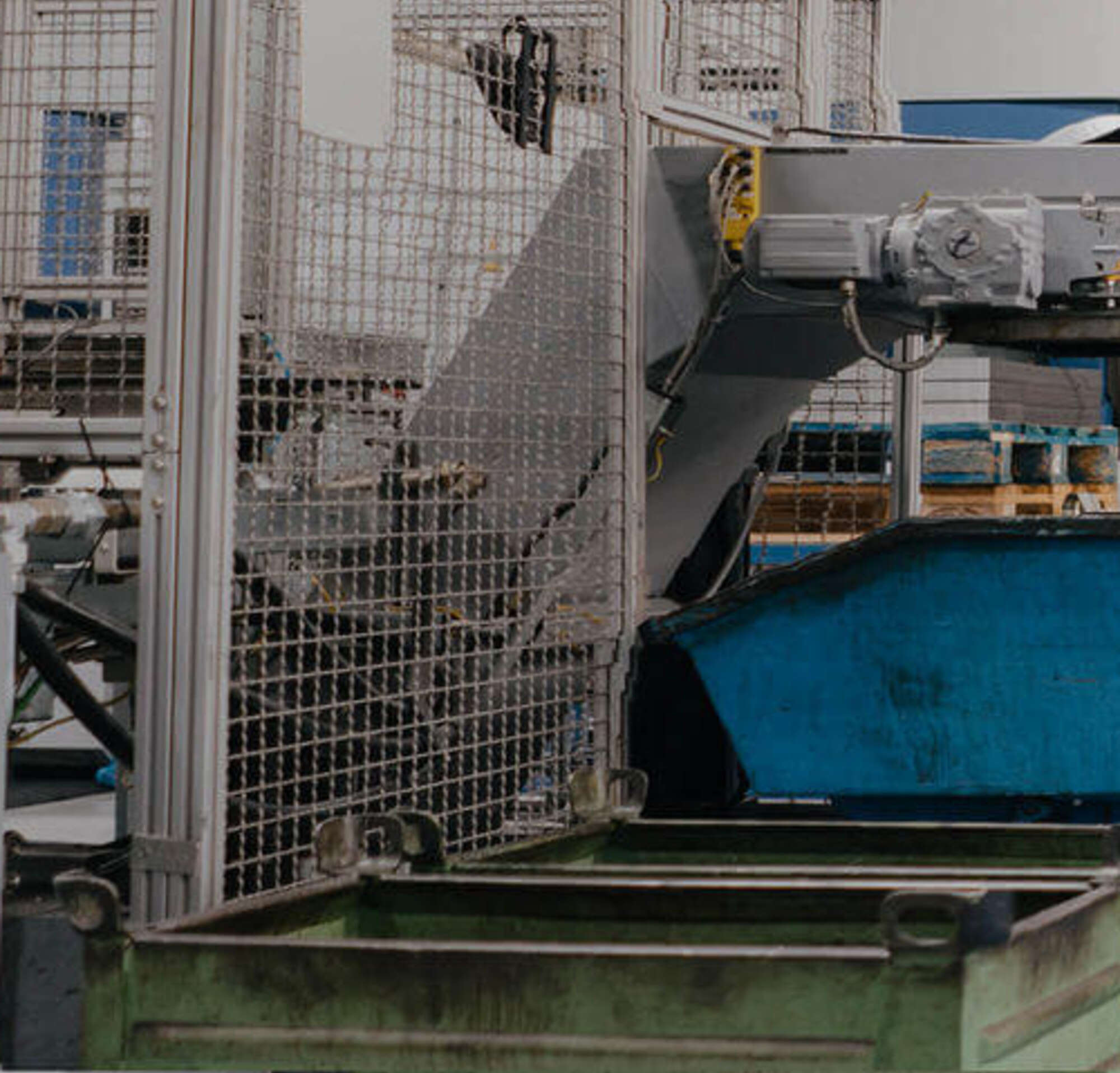 Un homme en costume et un ouvrier entre dans une usine avec de grosses machines.