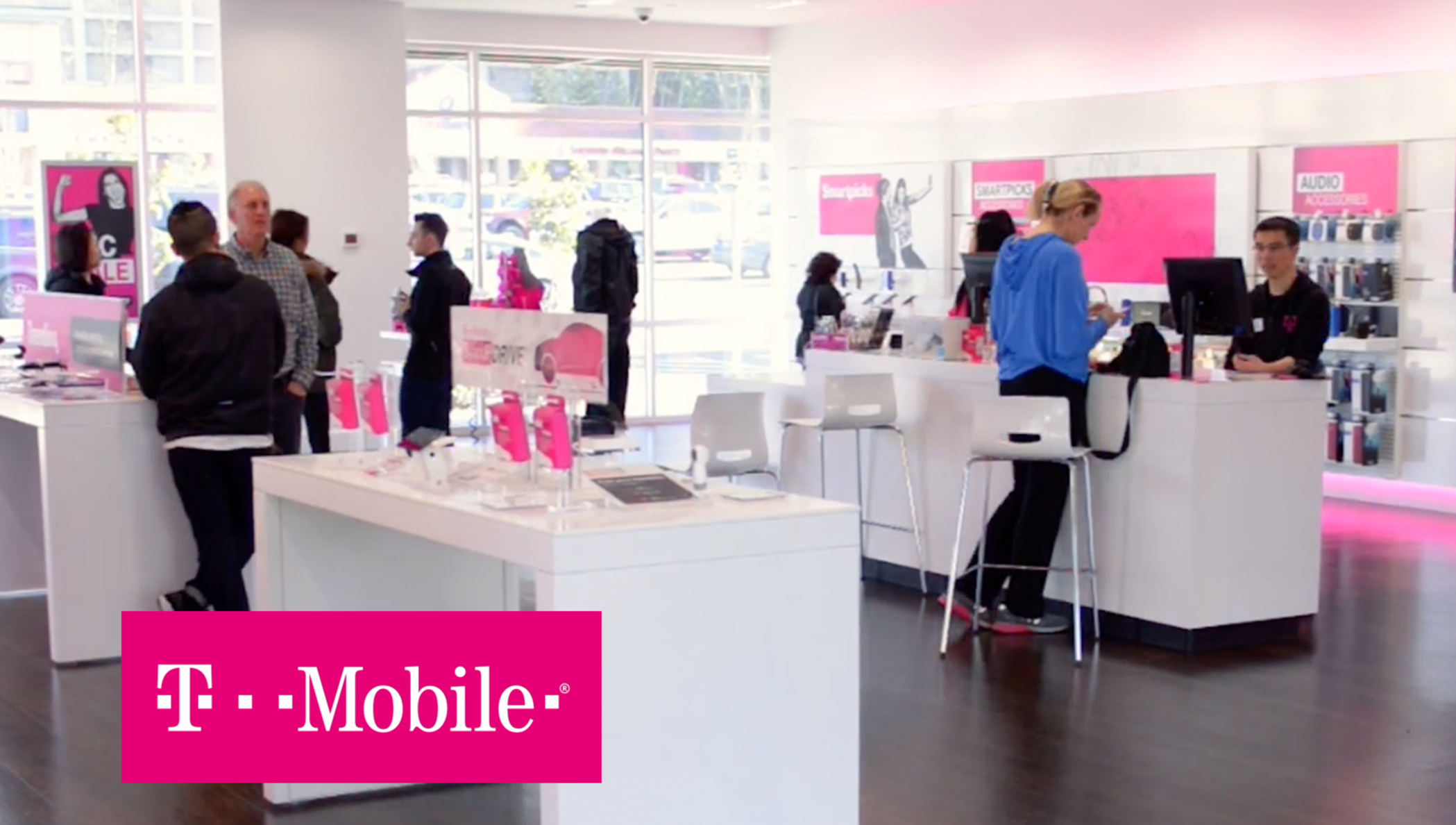 The interior of a T-mobile store with employees helping customers.