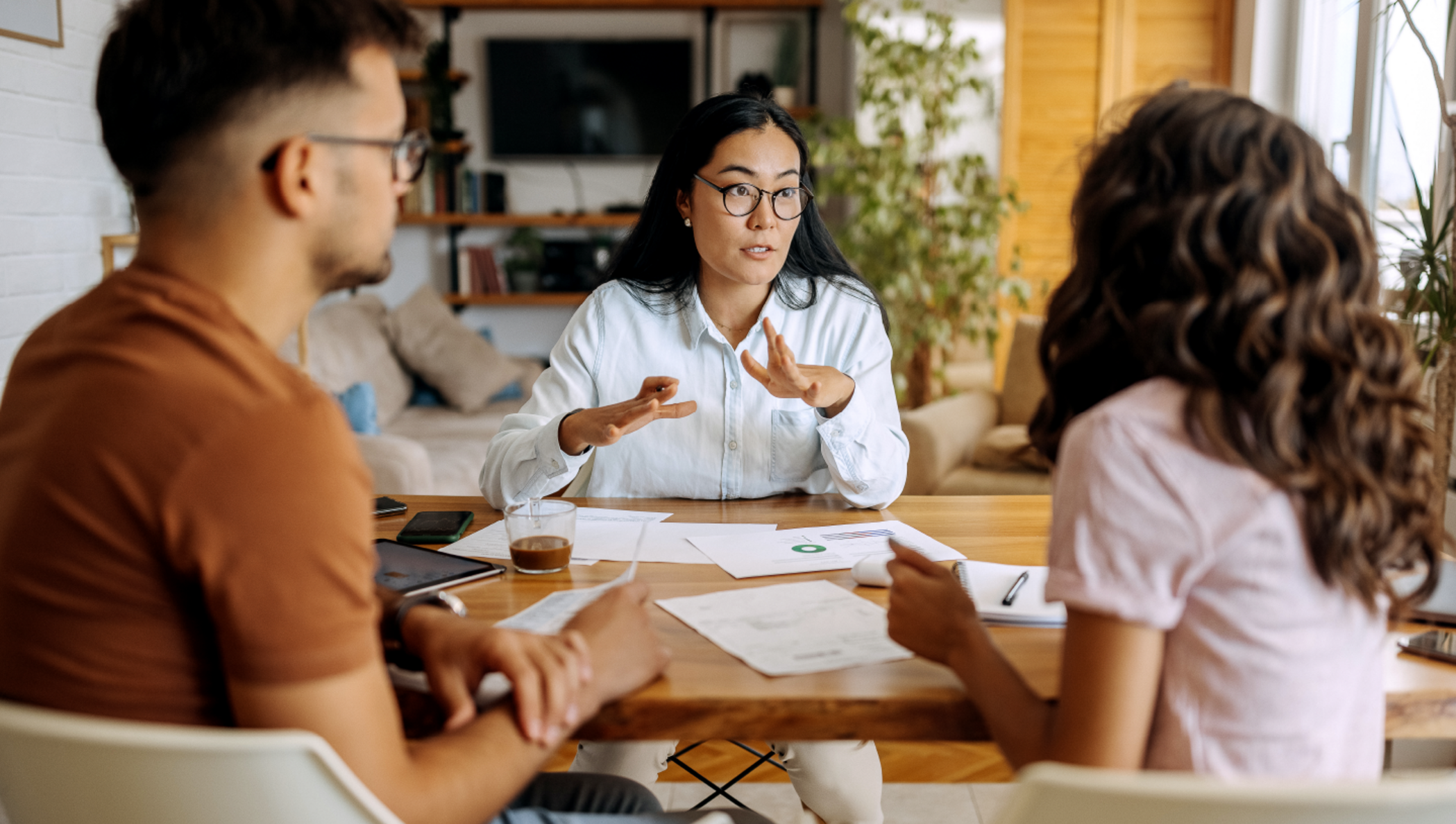Casal conversando com uma corretora em um escritório