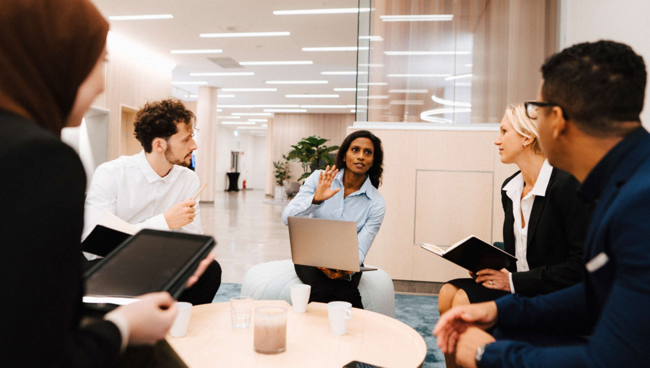 Colegas trabalhando ao redor de uma mesa de café no escritório