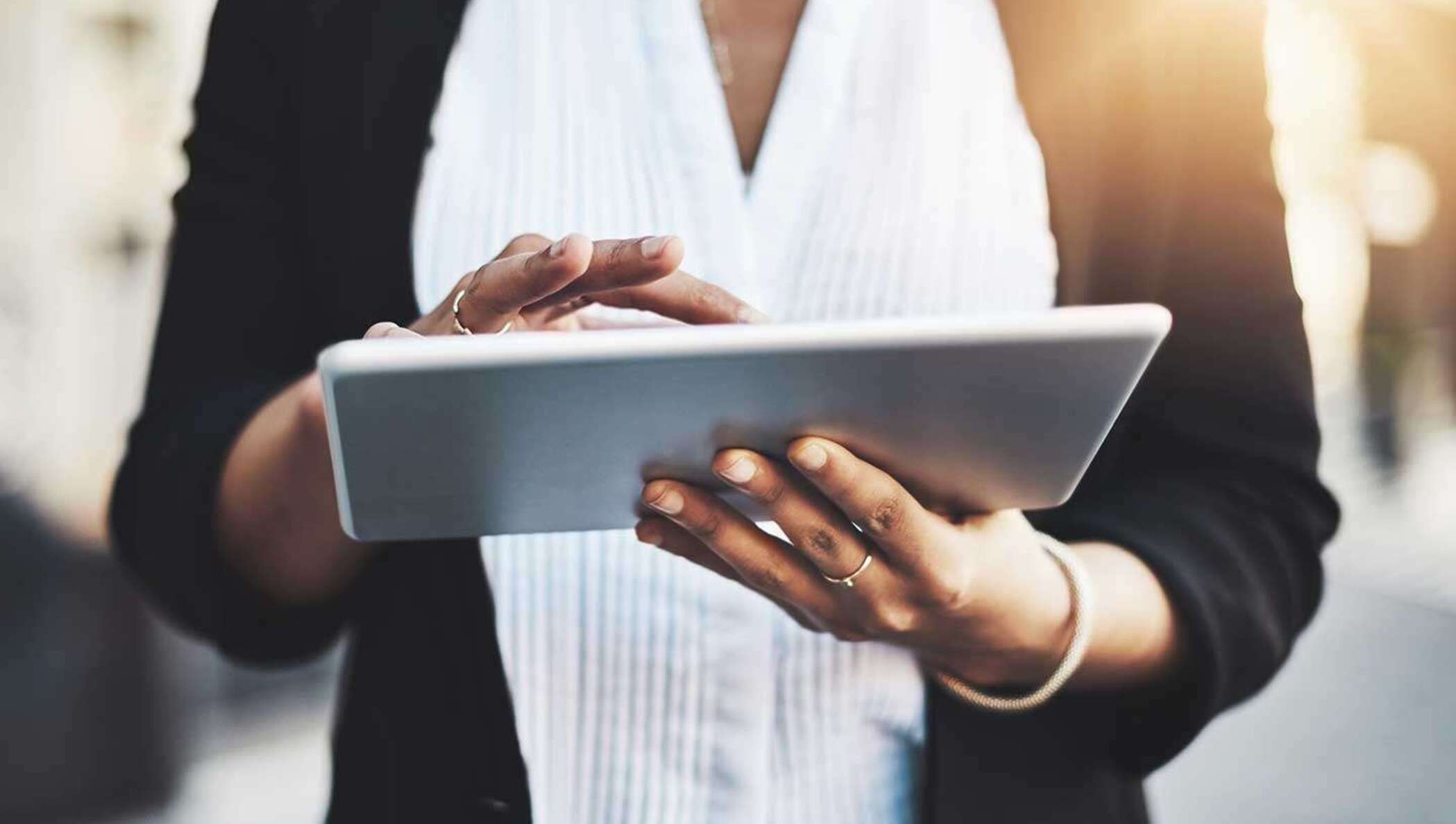 Eine Geschäftsfrau sucht auf ihrem Tablet nach Informationen zum Unterschreiben eines Dokuments