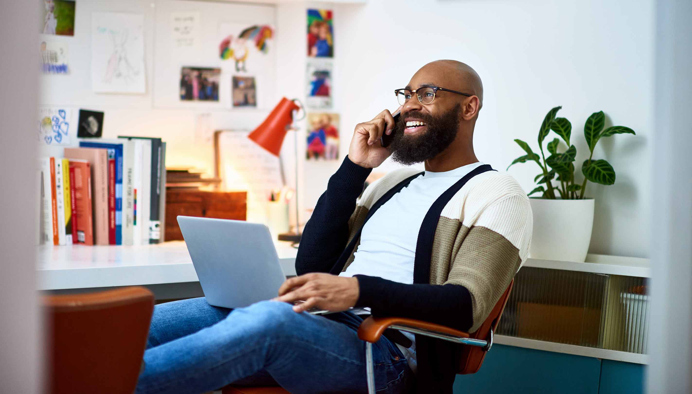 Homem sorrindo enquanto trabalha em casa de seu escritório